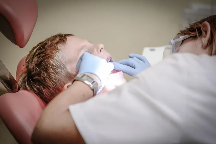 A young patient smiling in a dental chair during a check-up.